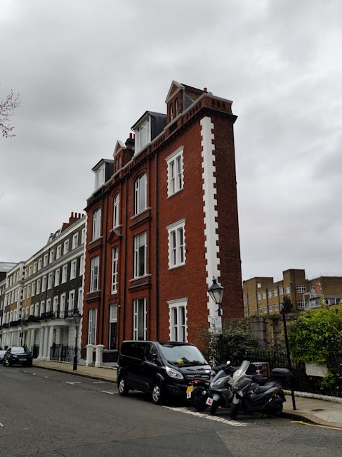 A brick residential building on Melbourne Terrace in Hammersmith and Fulham, London, featuring three white-framed windows on the upper floor and two ground-floor entrances with white doors and arched